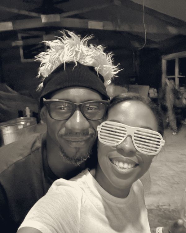 Michael and Brittany laughing in party hats and shutter shades