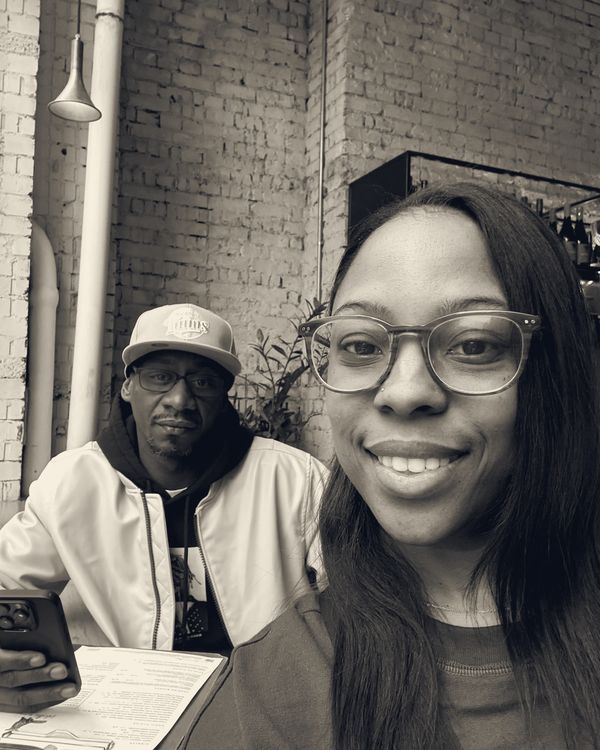 Brittany and Michael at a café with brick walls